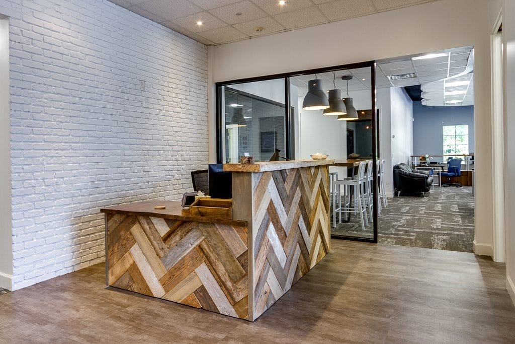 iMethods reception with herringbone wood desk and glass office walls