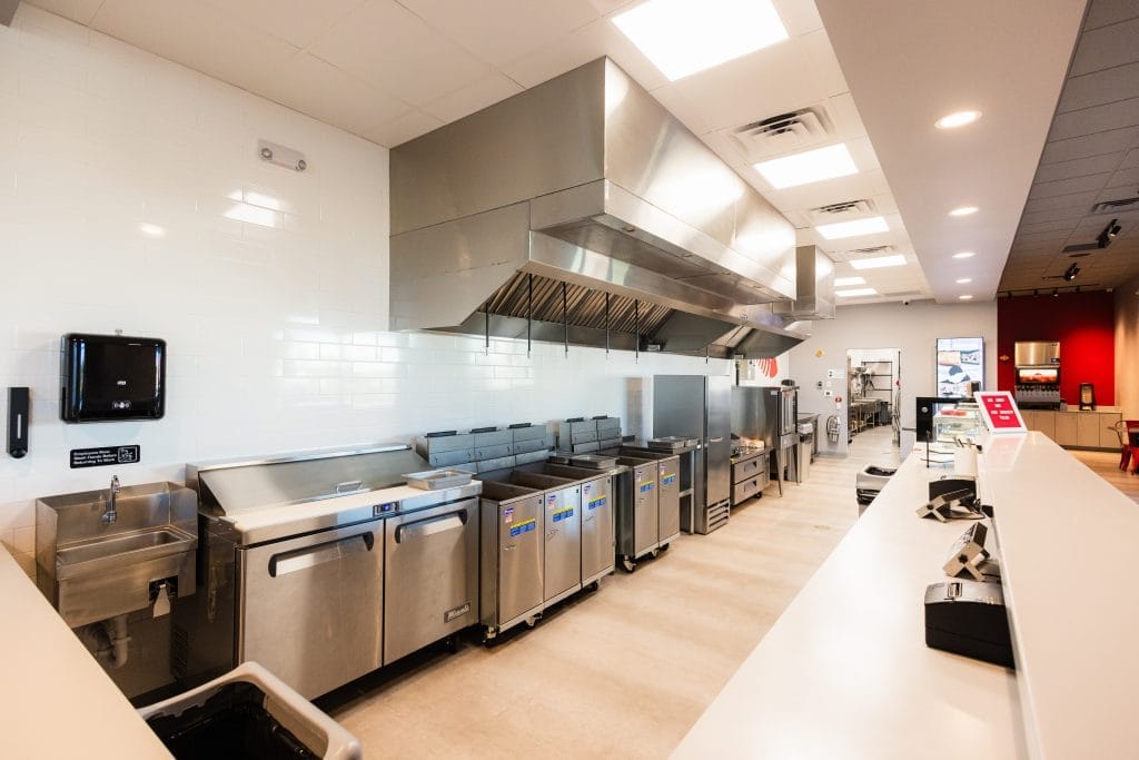 Commercial restaurant kitchen with stainless equipment and exhaust hood