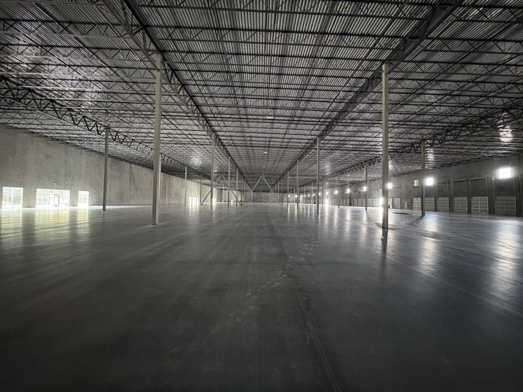warehouse interior contractor Jacksonville - Spacious warehouse interior with high ceilings and organized shelving, showcasin